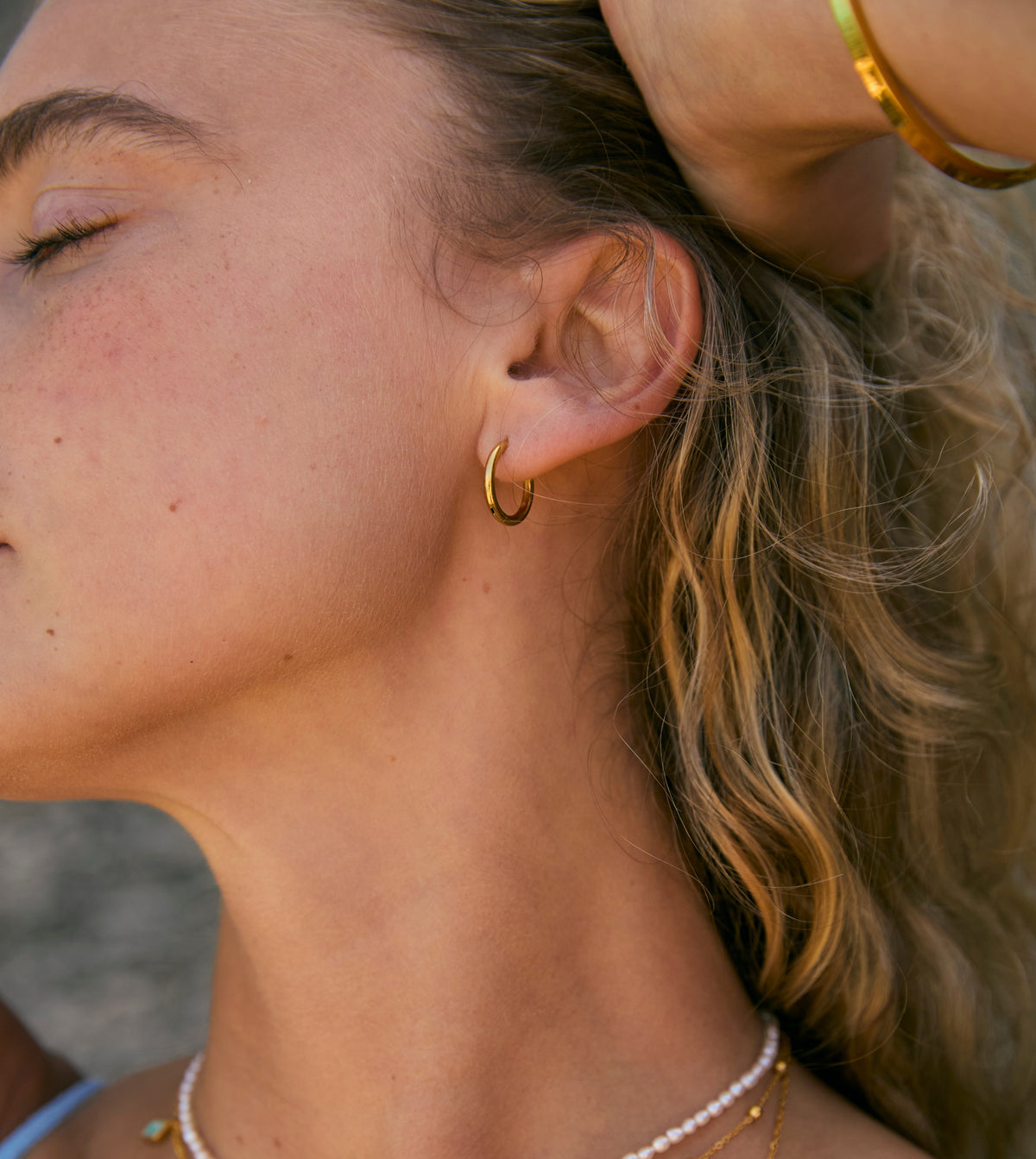 Model wearing Milly Grace waterproof gold hoops