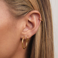 Gold Ultimate Midi Hoops 20mm styled on model in waterproof jewellery shoot
