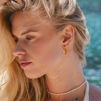 Gold Ultimate Cartilage Clickers 6mm close-up on ear with layered earrings